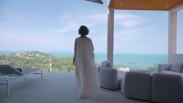 An elegant and sophisticated woman relaxing in a luxurious hotel room with a view of the ocean