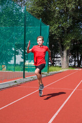 Fototapeta premium An athlete performs special running exercises at the stadium. 