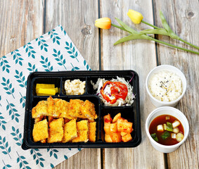 돈가스 도시락과 밥이 놓여있는 모습