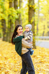 Fototapeta premium Woman holding toddler in autumn forest