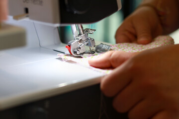 Young woman hand using a sewing machine. Seamstress concept