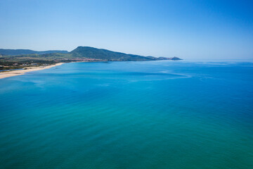 Drone aerial view of San Pietro a Mare wild beach coast with Castelsardo on the background in Sardinia, Italy
