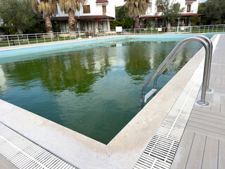 Swimming pool maintenance, dirty pool, Swimming pool with dirty green water close-up.