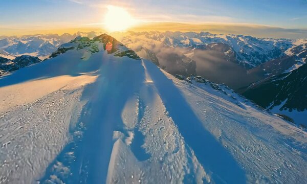 Aerial view snowy mountain during sunset. Cinematic shot.