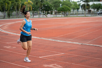 Asia mature woman runner training on racetrack and field	