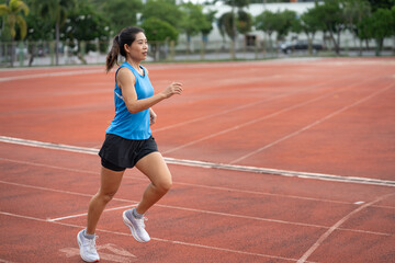 Obraz premium Asia mature woman runner training on racetrack and field 