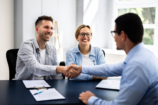 Young couple signing rental contract with real estate agent at apartment viewing