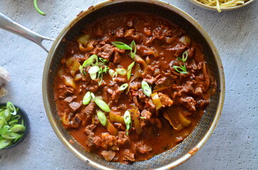 This classic homemade dish is served hot, highlighting its deep red color and aromatic spices.