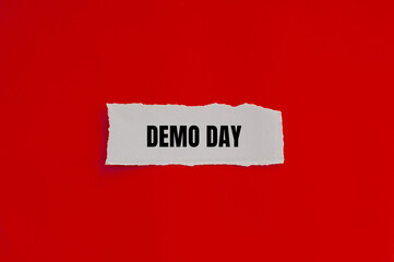Demo day message written on ripped torn paper piece with red background. Conceptual demo day...
