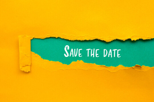 Save the date message written on ripped torn yellow paper with blue background. Conceptual save the date symbol. Copy space..