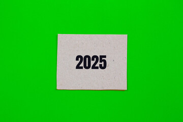 2025 message written on paper piece with green background. Conceptual 2025 symbol. Copy space.