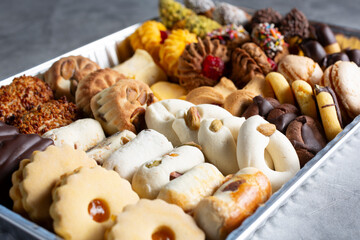 A closeup view of a tray of assorted petite four cookies.