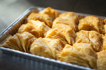 A closeup view of a tray of shaabiyat pastries.