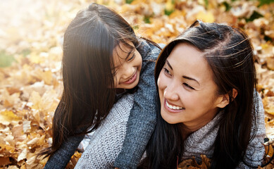 Naklejka premium Asian family, mom and daughter on floor in backyard for bonding, support and love on child development. Parent, kid and happy with hug to relax for childhood memories, trust and care at home together