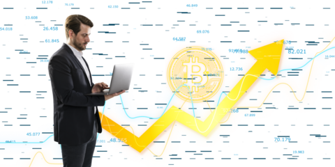 A businessman using a laptop with bitcoin and stock market graphics in the background, concept of cryptocurrency and finance