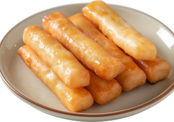 Close up of golden brown fried cheese sticks on a white plate.