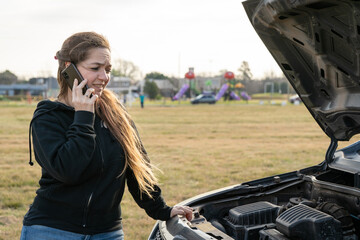 Mujer en apuros pidiendo asistencia por teléfono porque su auto se averió