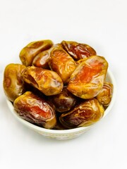Healthy dates in a bowl on white background 