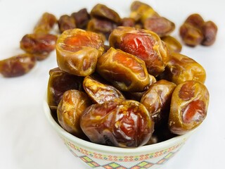 Fresh Arabian dates in a bowl on blurred background 