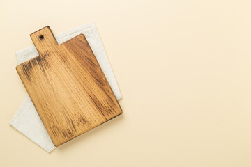 Cutting board with napkin on color background, top view