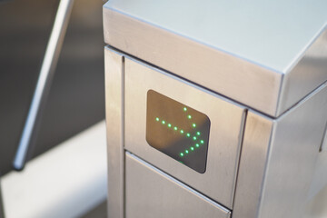 Modern turnstile gate with green arrow indicator for direction control at access checkpoint