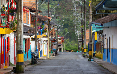 Fototapeta premium Street in Jardin, Jardín, Antioquia, Colombia. Green background, colorful colonial facades and houses.