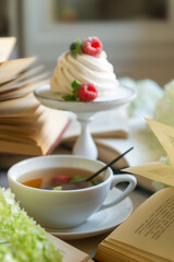 Tea in a beautiful white cup, cake with berries and white hydrangea flowers.