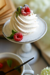 Tea in a beautiful white cup, cake with berries and white hydrangea flowers.