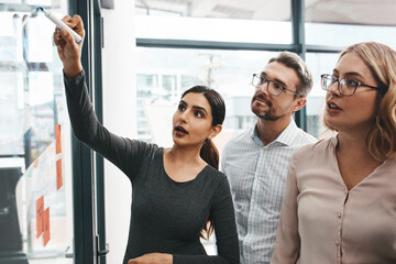 Woman, teamwork and office with writing on board with notes, discussion and planning with...