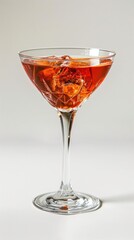 Red cocktail with ice and orange slice in martini glass