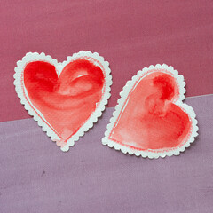 close-up of two vintage-styled paper hearts with scalloped edged lacy border on purple