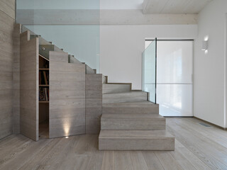 interior of a modern home in the foreground the wooden staircase