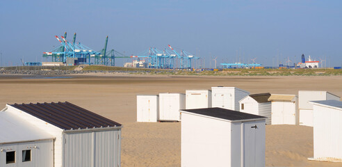 Port of Bruges with Albert II dock as seen from the  beach with cabanas with clear blue sky in...