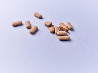 Ashwagandha (Withania somnifera) tablets on paper background. Soft focus. Close up. Copy space.	