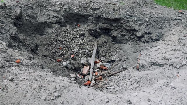 A crater from a rocket attack. Consequences of a rocket attack.