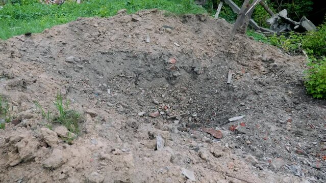 A crater from a rocket attack. Consequences of a rocket attack.