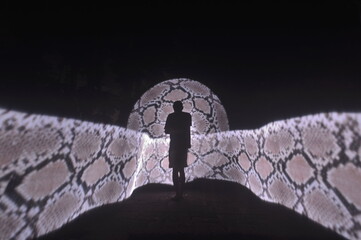 One person standing alone against a Colourful circle light painting as the backdrop	
