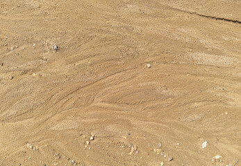 Sand on the beach as an abstract background. Sand deposits after water flow. Texture. Pattern. Selective focus