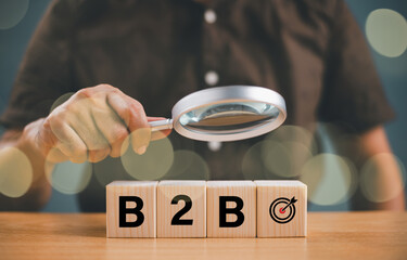 B2B market enterprise concept. Ecommerce research marketing, Business to Business content, e-commerce technology. Business company commerce digital marketing. Man hold glass on wood block background