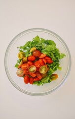 salad bowl with cherry tomatoes and lettuce on a white background