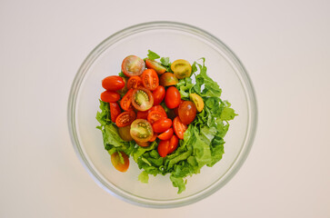 salad bowl with cherry tomatoes and lettuce on a white background