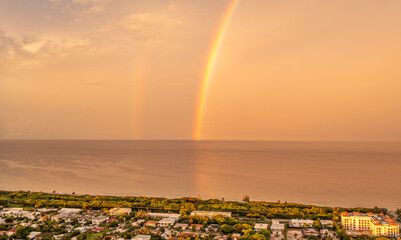 Rainbow setting in the ocean hazy sunset.