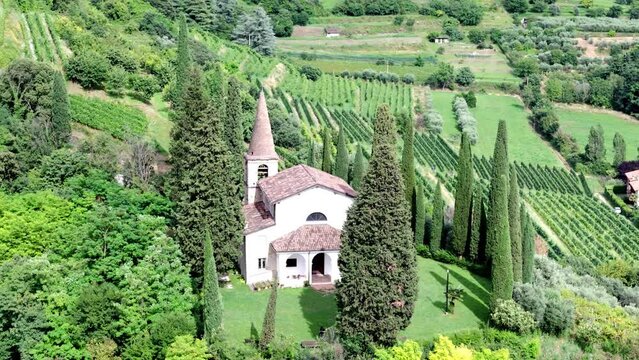 Aerial orbit view of Franciacorta vineyards with San Rocco church in the foreground, Brescia province, Lombardy district, Italy.
