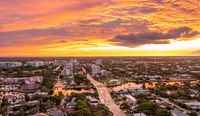 Dramatic sunset over Boca Raton, Florida with yellow, gold, orange, and mauve colors in the sky.