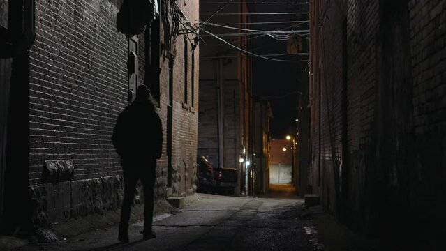 Mysterious person walking down dark alley in city 4k

