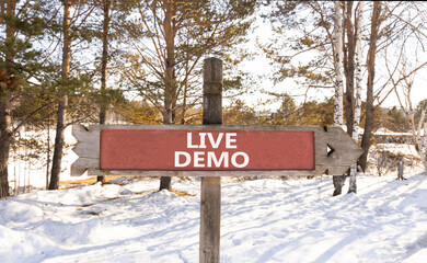 Live demo symbol. Concept words Live demo on beautiful wooden road sign. Beautiful forest snow blue...