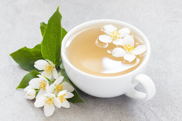 Tea with jasmine in a cup. Light gray background. Close up