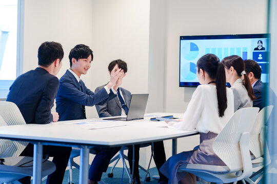 スーツを着て会議で話す若い男性