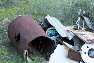 Piles of garbage thrown in the forest, human negligence over nature, scrap metal