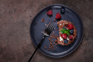 half-eaten chocolate tartlet, on a plate, stuffed with cottage cheese and berries, breakfast, homemade, no people,